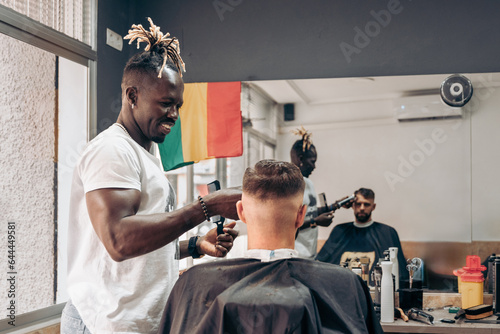 Man getting professional haircut in barbershop photo