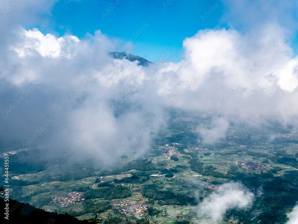 view of cities from the top of the mountain with thick white clouds covering it