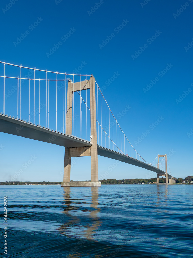Den nye Lillebæltsbro stretching from Funen to Jutland in Denmark across the Lillebælt strait. Blue sky and sunny summer weather. Den nye Lillebæltsbro stretching from Funen to Jutland in Denmark across the Lillebælt strait. Blue sky and sunny summer weather.