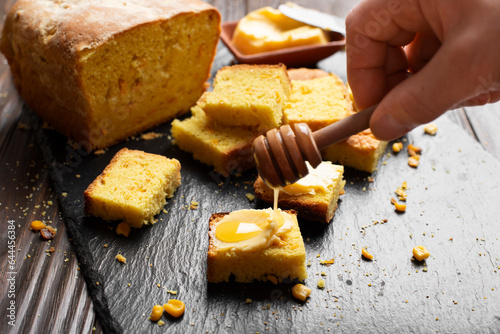 Sweet Honey Butter homemade cornbread slices on kitchen table photo