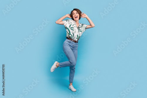 Full length photo of impressed funky woman dressed print shirt looking empty space isolated blue color background
