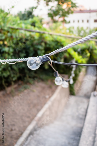 light bulbs on wires above stairs of street in Yerevan city, Armenia photo