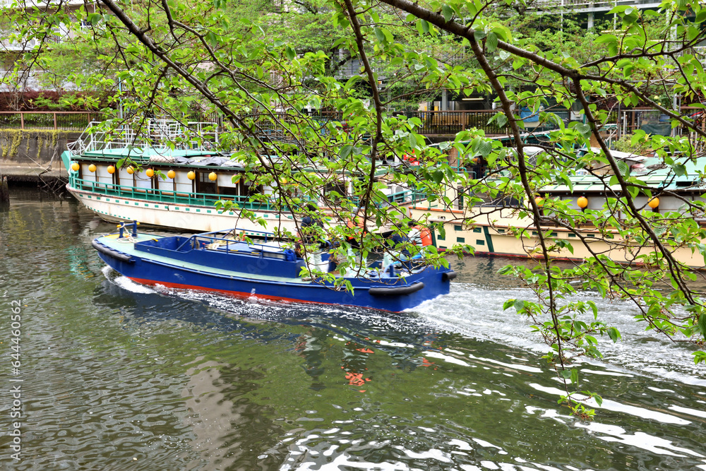 	月島川水門近くに停留する屋形船と隅田川に向かうボート
