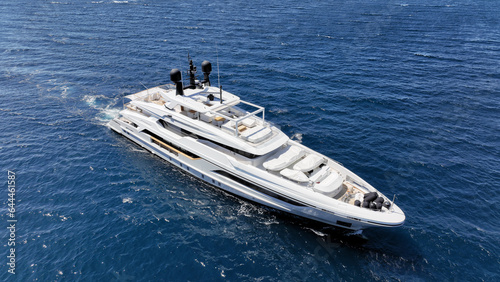 Aerial drone photo of beautiful modern super yacht with wooden deck cruising in low speed deep blue Aegean sea © aerial-drone