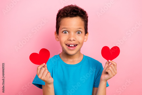 Photo portrait of сute little boy excited hold two red postcards date dressed stylish blue clothes isolated on pink color background