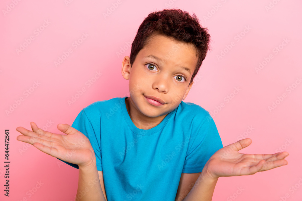 Photo of doubtful unsure small boy wear blue t-shirt shrugging shoulders isolated pink color background Photo of doubtful unsure small boy wear blue t-shirt shrugging shoulders isolated pink color background