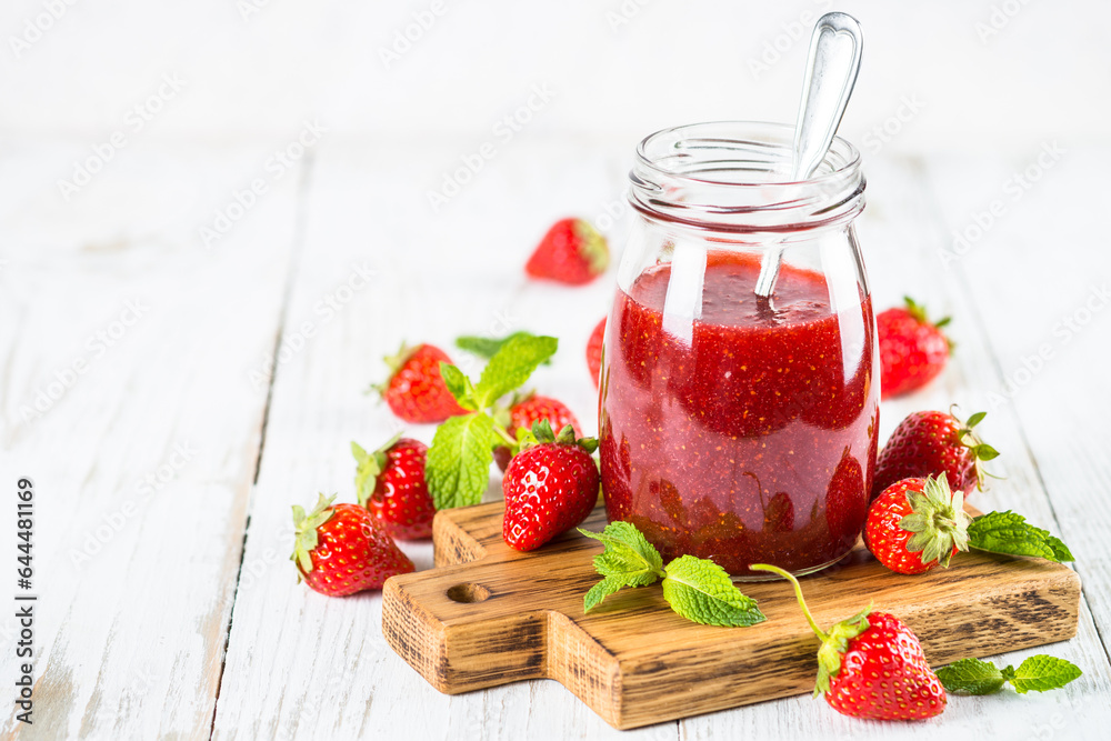Strawberry jam in the glass jar at white table. Strawberry jam in the glass jar at white table.
