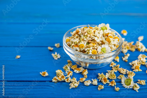 Dry chamomile flowers on a wooden table. Soothing chamomile tea. Herbal drink. flat layout. Space for text.Copy space.Medical prevention and immune concept. Folk alternative medicine.