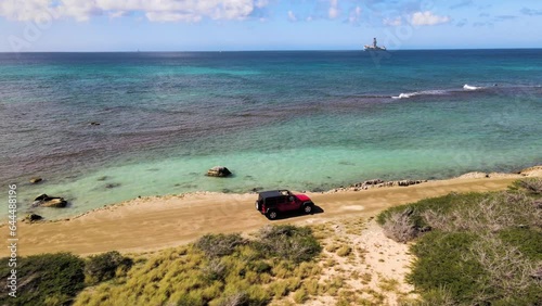 Aerial view of a car driving on the cliff along the coastline in Westpunt, Noord, Aruba photo