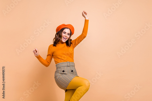 Foto Photo of joyful funky girl wear trendy orange clothes raise hands enjoy weekend
