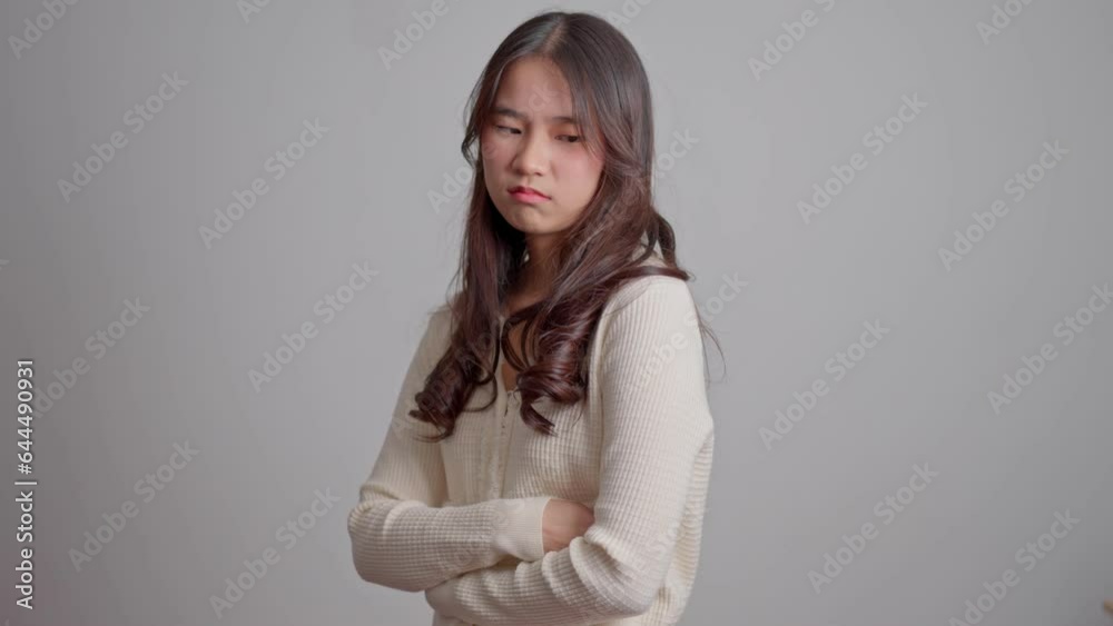 Portrait of Asian angry and sad hipster girl on a white screen background, The emotion of a hipster when tantrum and mad, expression of grumpy emotion. Teenager emotional control concept Portrait of Asian angry and sad hipster girl on a white screen background, The emotion of a hipster when tantrum and mad, expression of grumpy emotion. Teenager emotional control concept