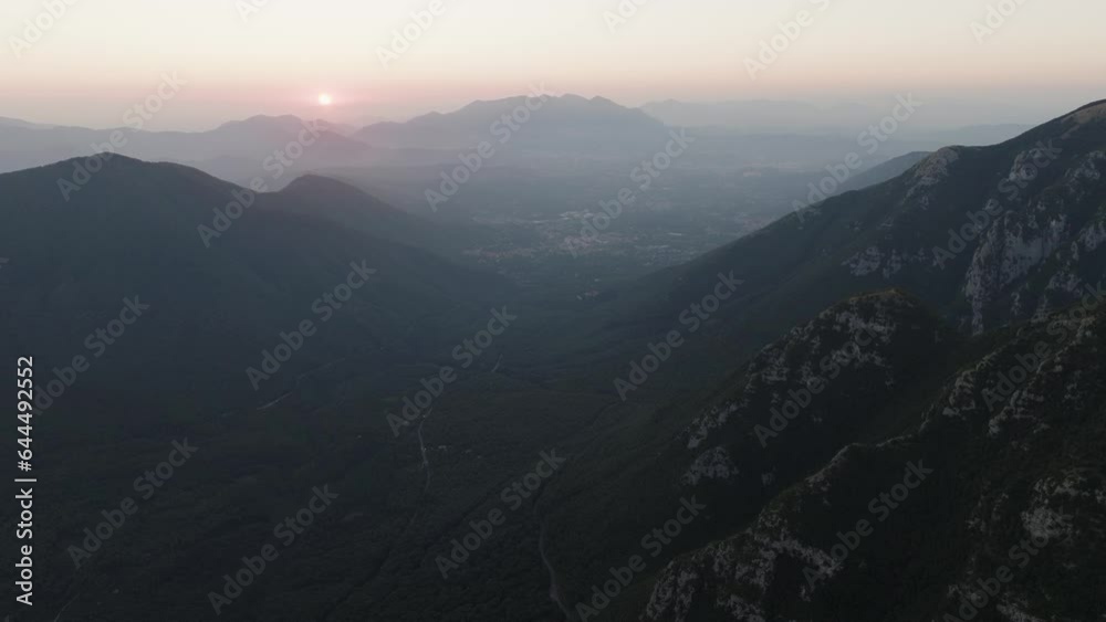 Aerial view of the sun setting down across the valley in Serino along the Mount Terminio with National park, Campania, Avellino, Italy. Aerial view of the sun setting down across the valley in Serino along the Mount Terminio with National park, Campania, Avellino, Italy.