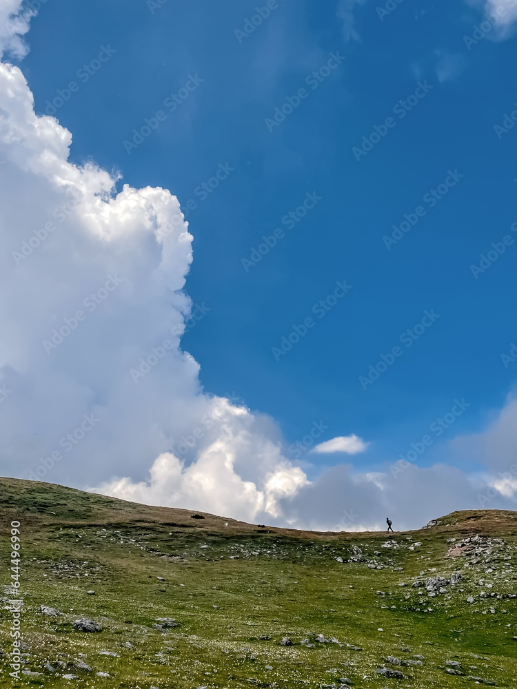 Small Person in large Mountain Landscape with Clouds