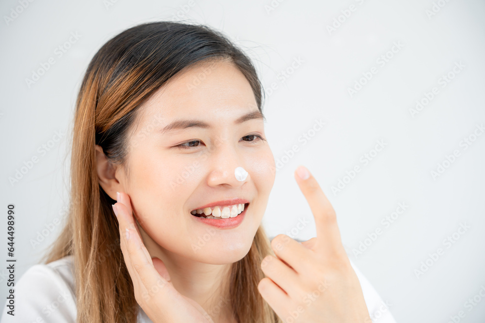 Beautiful Asian woman smile use cream touch on nose skin. face of a healthy woman apply cream and makeup. Advertisement for skin cream, anti-wrinkle, baby face, whitening, moisturizer, tighten pores Beautiful Asian woman smile use cream touch on nose skin. face of a healthy woman apply cream and makeup. Advertisement for skin cream, anti-wrinkle, baby face, whitening, moisturizer, tighten pores
