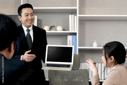 Businesspeople discussing at conference office desk, senior businessman showing laptop computer for presentation at group board meeting, agreement on negotiation deal, successful company teamwork.