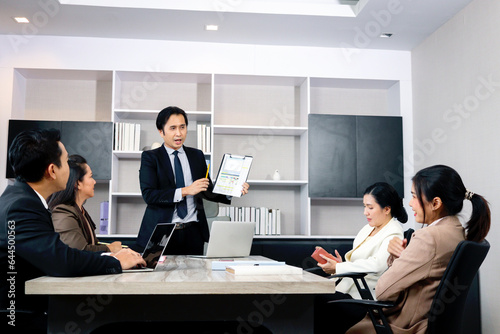 Businesspeople discussing at conference office desk, businessman showing paper report chart for presentation at group board meeting, agreement on negotiation deal, successful company teamwork meeting.