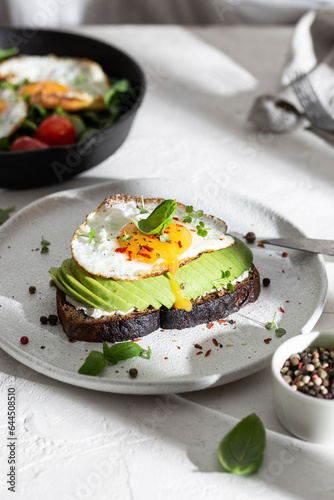 Breakfast wirh toast with avocado and eggs on a plate