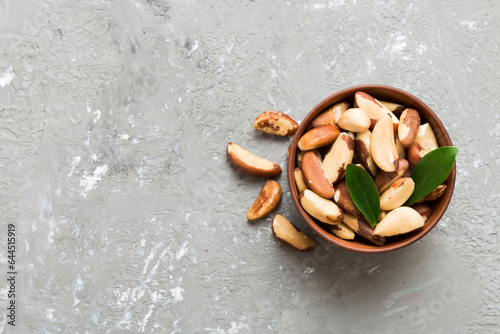 Fresh healthy Brazil nuts in bowl on colored table background. Top view Healthy eating bertholletia concept. Super foods photo