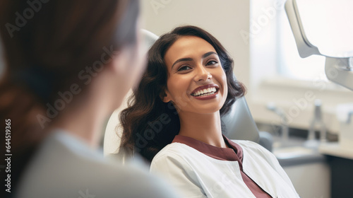 A mixed individual sitting and smiling in a dentist's office, radiating comfort and confidence in healthcare settings.