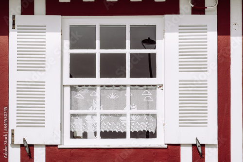 Vintage window with white shutters on a typical red and white striped wall, Costa Nova, Aveiro, Portugal photo