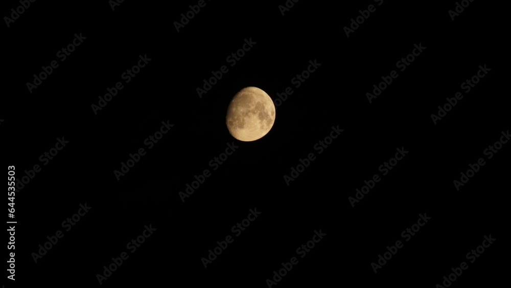 Clear moon with clouds sets. The partly clear moon is setting down. Black clouds float against the backdrop of the yellow moon with craters. 4k footage video. Close-up. Natural satellite of Earth Clear moon with clouds sets. The partly clear moon is setting down. Black clouds float against the backdrop of the yellow moon with craters. 4k footage video. Close-up. Natural satellite of Earth