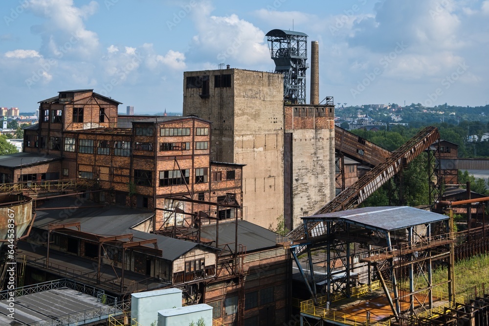 Historic industrial area in Ostrava, Czech Republic. Damaged industrial building with a mining tower in the background Historic industrial area in Ostrava, Czech Republic. Damaged industrial building with a mining tower in the background
