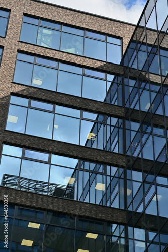 Low-angle view of modern office building with reflections in the windows