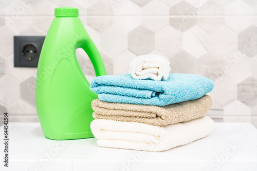 Stack of bath towels and detergent. Clean towels in the laundry or bathroom.