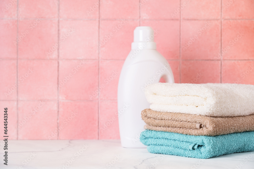 Clean towels and detergent in the laundry or bathroom against tile wall.
