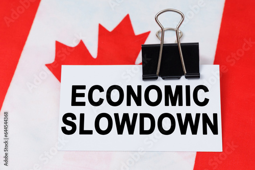 On the flag of Canada lies a business card with the inscription - economic slowdown photo