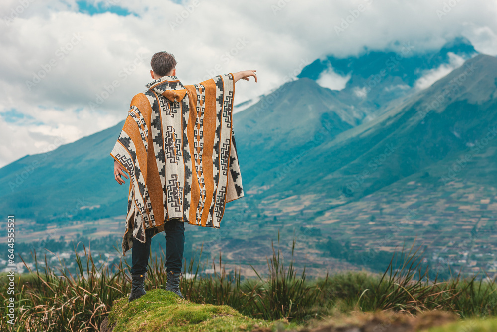 Model wearing a poncho handmade with sheep cloth by the indigenous Kichwa artisan communities of the area, posing at the San Pablo lake in Otavalo, Ecuador. - obrazy, fototapety, plakaty 