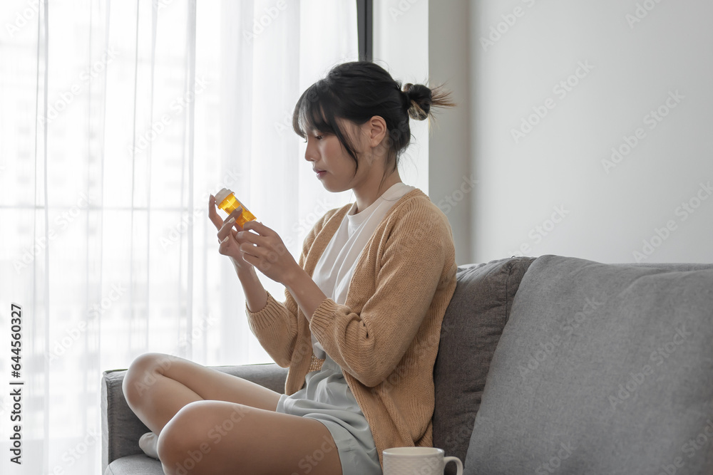 Asian woman Search for information on Internet in smartphone with holding bottled drug. girl reading information online on mobile phone medicine healthcare product concept.