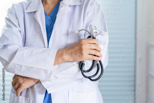 senior asian woman doctor wearing glasses and uniform with stethoscope in hand Healthcare and medical concept