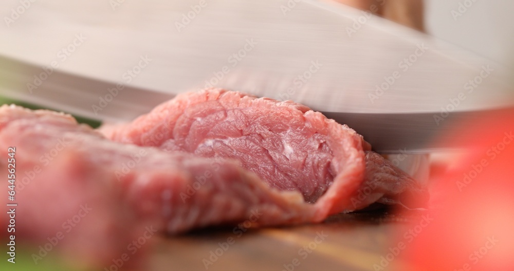 Cutting raw meat. Female hands cut fresh beef on a wooden chopping board. Cooking in the kitchen. Food preparation. Cutting raw meat. Female hands cut fresh beef on a wooden chopping board. Cooking in the kitchen. Food preparation.