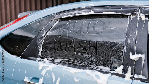 Car wash. The machine asks to be washed. The machine is doused with foam photo