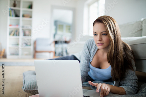 Young woman using a laptop in the living room at home