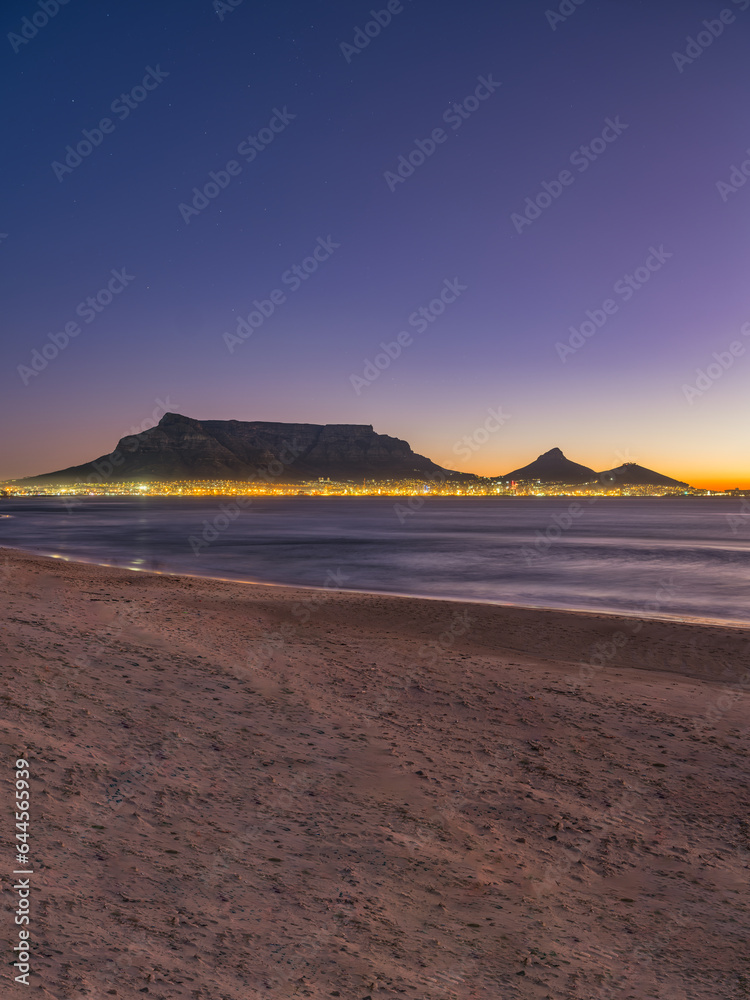 Vertical shot of Cape Town city lights with and table mountain loin's head in the background, Cape Town, South Africa Vertical shot of Cape Town city lights with and table mountain loin's head in the background, Cape Town, South Africa