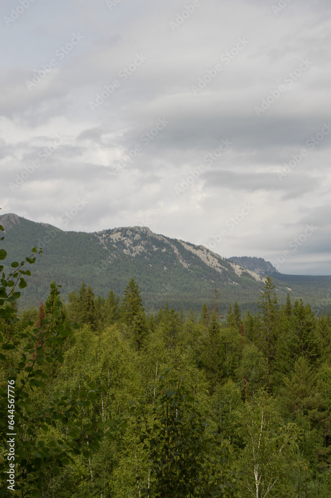 Mountain landscape with cloudy sky. Landscapes of Taganay. Vertical photo