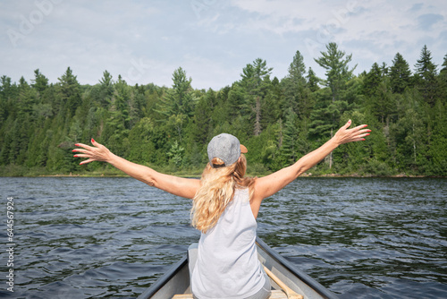 Mujer feliz en canoa en un lago 