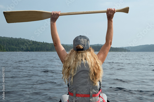 Mujer con remo en canoa en un lago