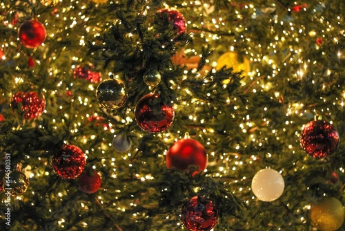 Background from a luminous Christmas garland and balls on a Christmas tree