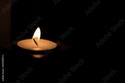 Close-up of flame burning on candle isolated on a black background. - Center Left