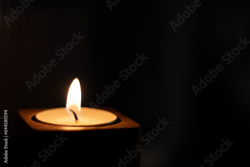 Close-up of flame burning on candle isolated on a black background. - Bottom Left Corner