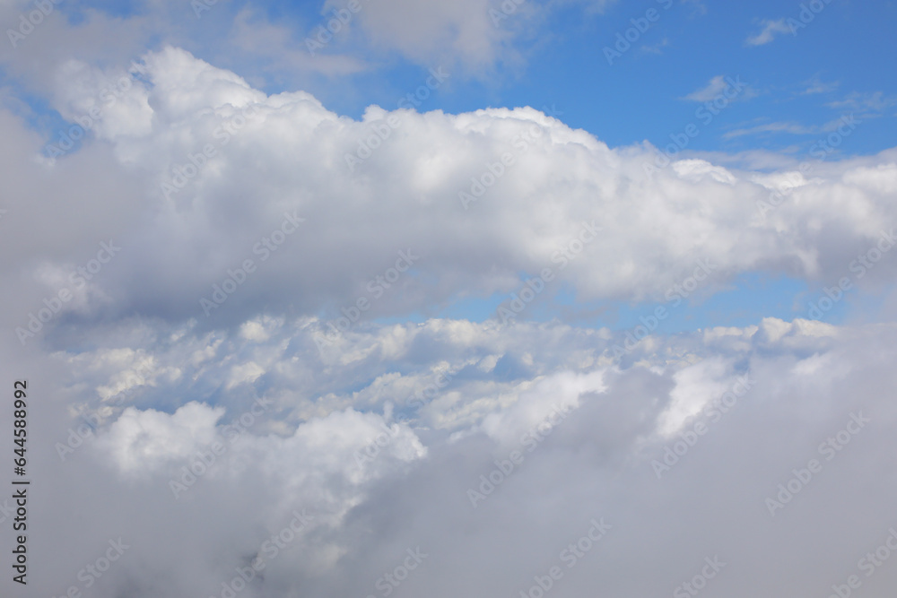 view of the white clouds and blue sky from the window of an aircraft during the journey view of the white clouds and blue sky from the window of an aircraft during the journey