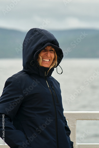 Mujer en un barco en travesía por un lago con lluvia y viento