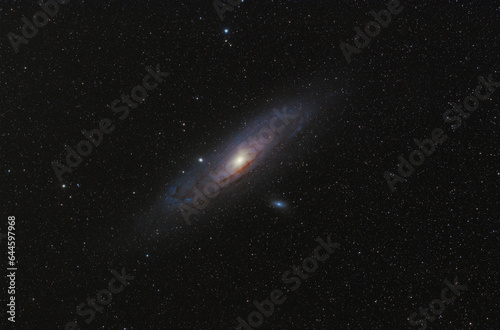 Andromeda Galaxy (M31) and its satellite galaxies (M32 and M110) in Andromeda constellation against widefield night starry sky