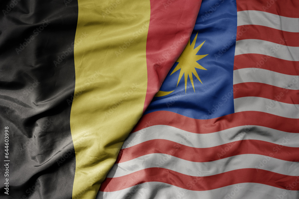 big waving national colorful flag of belgium and national flag of malaysia .