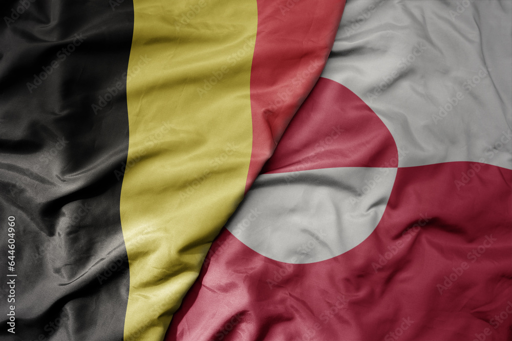 big waving national colorful flag of belgium and national flag of greenland .