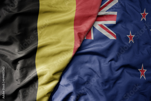big waving national colorful flag of belgium and national flag of new zealand . © luzitanija