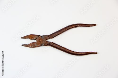 Open rusty pliers on a white background